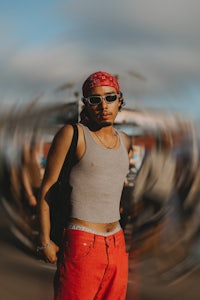 a man in a red bandana standing in front of a blurry background