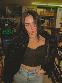 a woman in a black top and jeans standing in a store